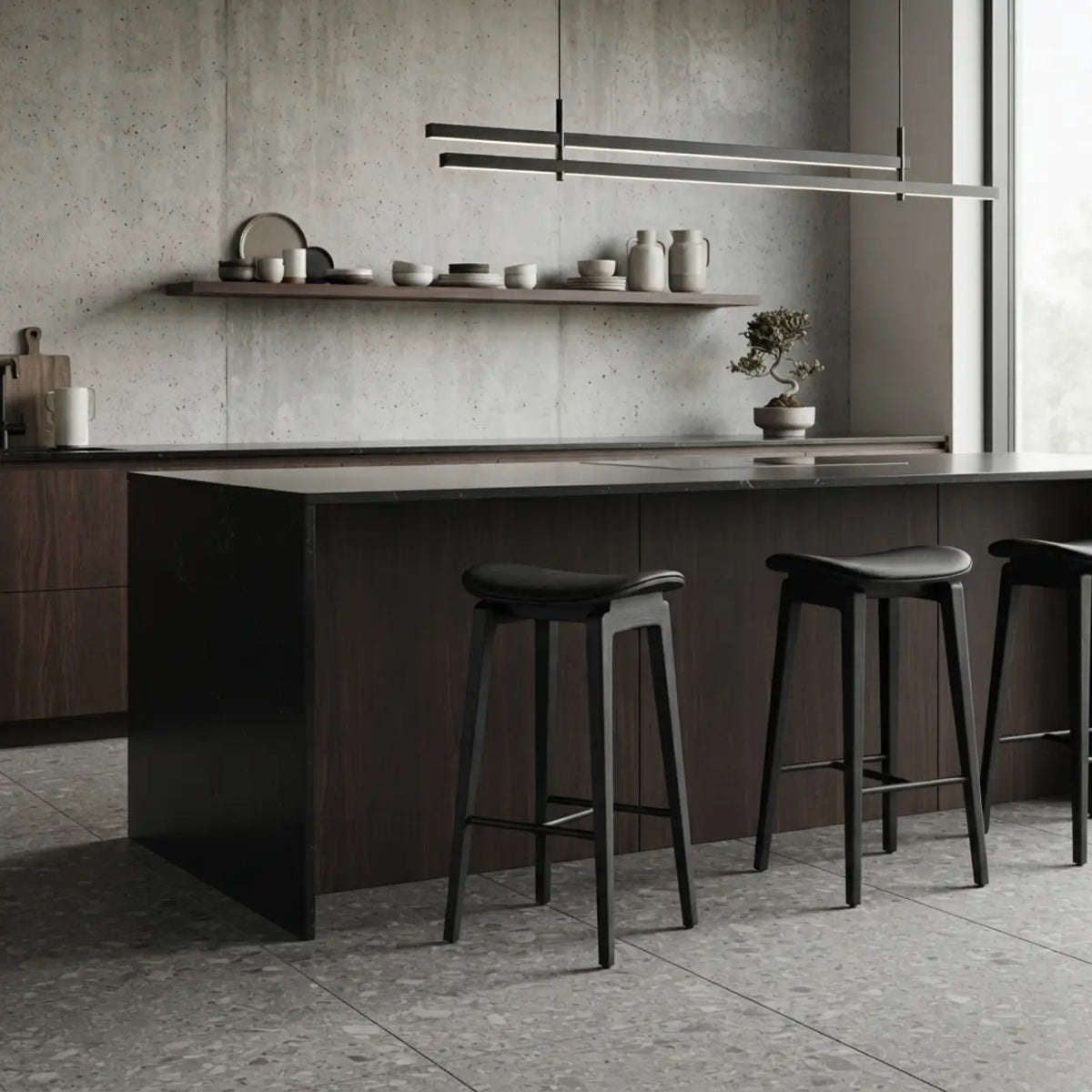 Row of black faux leather counter stools with curved seats, dark wood frames and black footrests at a contemporary kitchen island