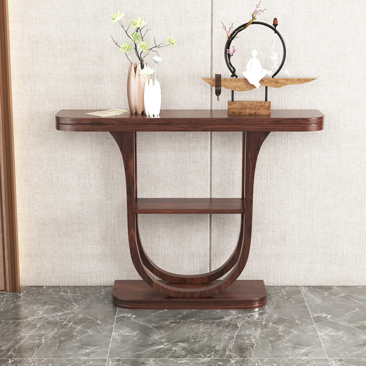 Rich brown demilune entryway console table with shelf against a paneled wall, styled with vases and a sculpture