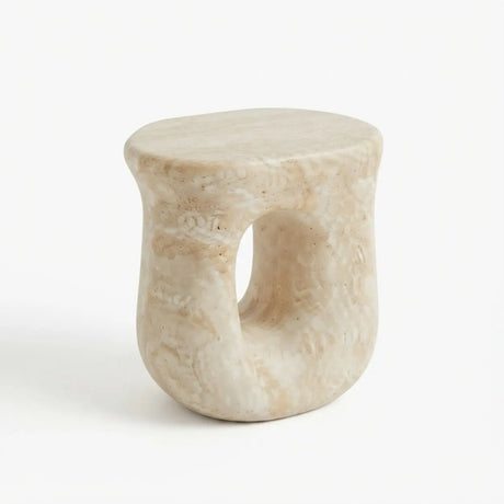 Faux travertine stone oval side table with a rounded top and hollow curved base isolated on a white background