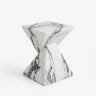 White veined faux stone side table with a twisted geometric pedestal isolated on a white background