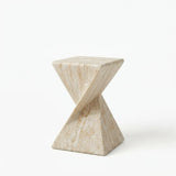 Travertine faux stone side table with a rounded square top and twisted geometric pedestal isolated on a white background