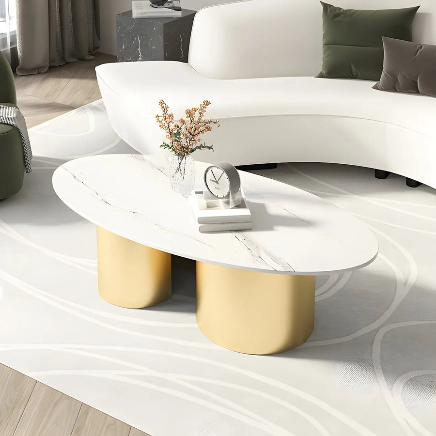 Fourteen-inch low oval coffee table with an abstract metal base beside a curved sofa