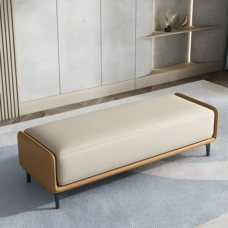 Tan frame bedroom bench with cream leather upholstered seat on a blue rug by white wood-slat wall panels
