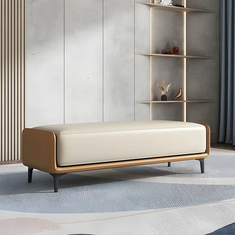 Tan caramel frame bench with cream leather upholstered seat on a blue rug against grey shelving wall